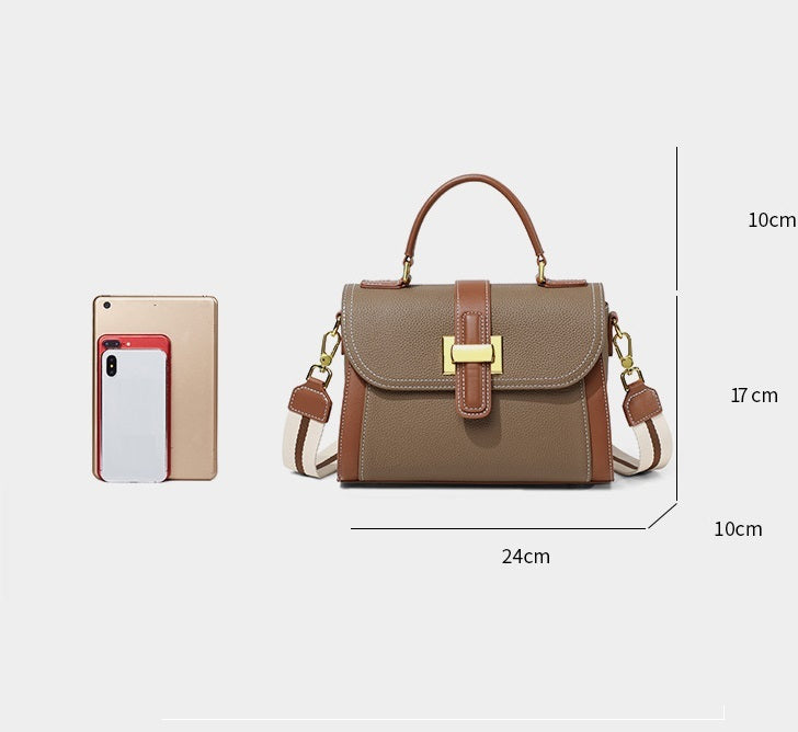 Brown handbag with gold accents next to a smartphone for size comparison on a white background