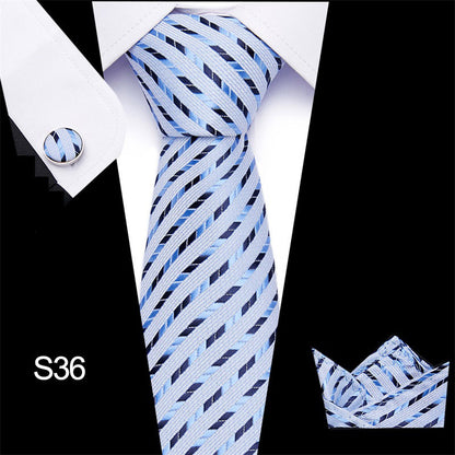 Blue striped tie with matching cufflinks and pocket square on a black background