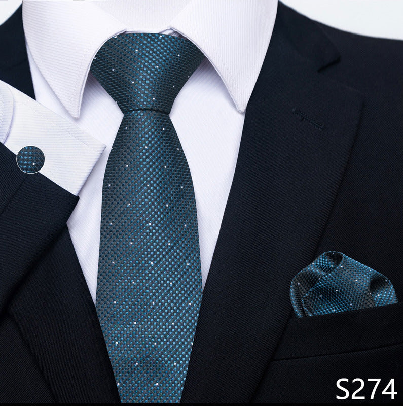 Teal patterned tie and pocket square set with a black suit and white shirt.