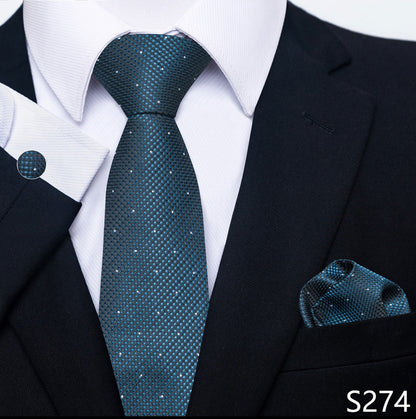 Teal patterned tie and pocket square set with a black suit and white shirt.