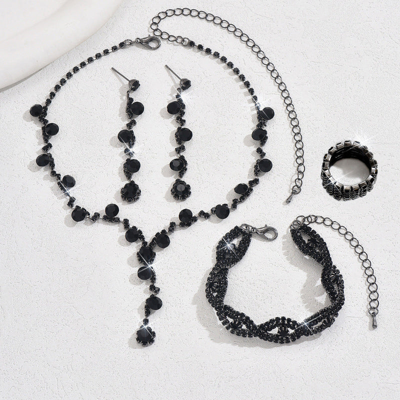 Black beaded jewelry set including necklace, bracelet, ring, and earrings on a white background