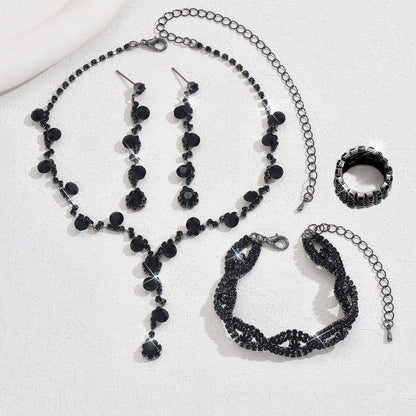 Black beaded jewelry set including necklace, bracelet, ring, and earrings on a white background