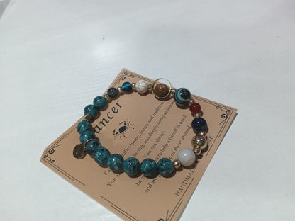 Zodiac charm bracelet with mixed blue stone beads and gold-tone spacer beads