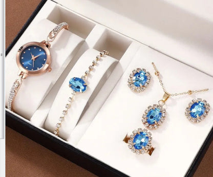 Jewelry set with watch, bracelet, and earrings featuring blue gemstones in a box.