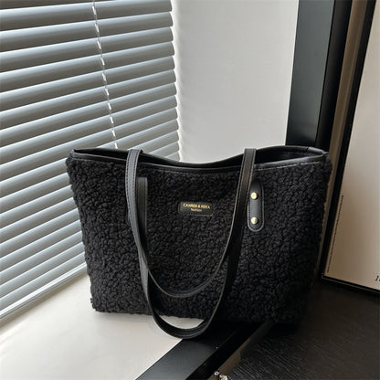 Black furry tote shoulder bag with dual handles, front pocket, and gold buttons