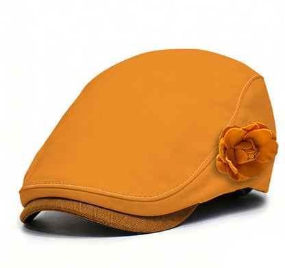 Orange fabric beret with orange flower accent and warm-toned brim trim.