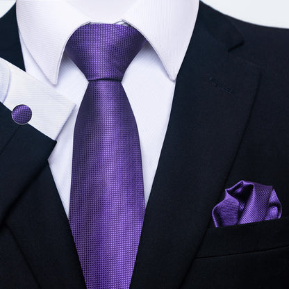 Black suit with a purple tie and pocket square on a white background