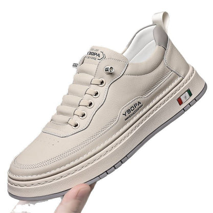 Beige sneaker with brand logo held by a hand on a white background