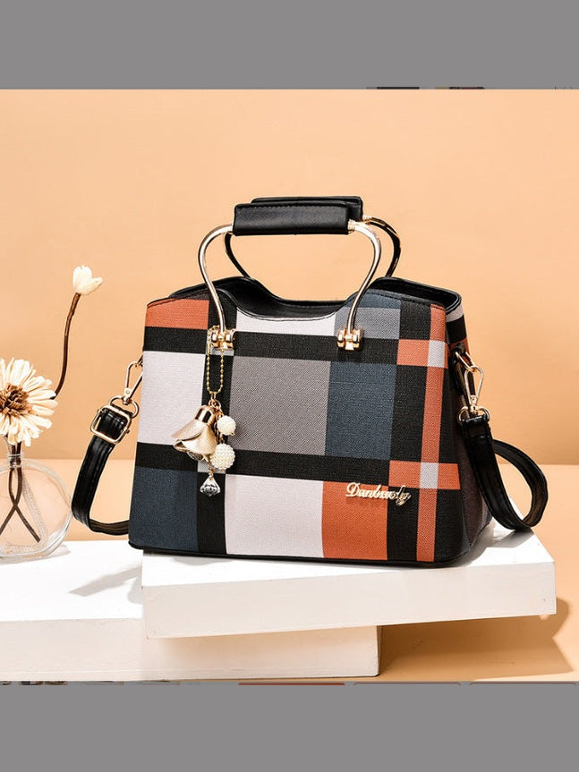 Colorful checkered handbag with decorative elements on a beige background