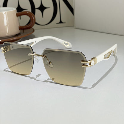 Gold sunglasses with gradient lenses on a light surface, with a blurred background
