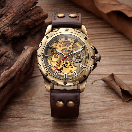 Gold mechanical watch with brown leather strap on a wooden surface