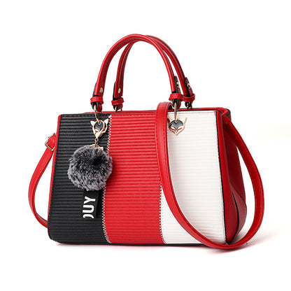 Multicolored handbag with red, black, and white sections on a white background