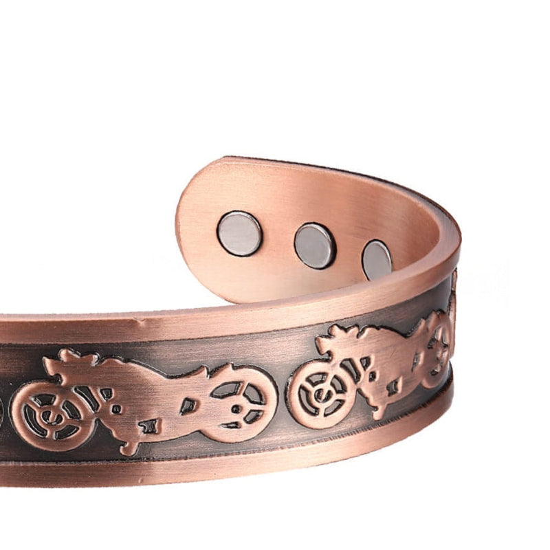 Copper bracelet with engraved designs on a white background