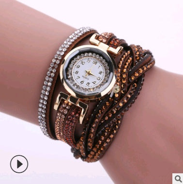 Multilayered bracelet with a watch face on a wrist against a white background
