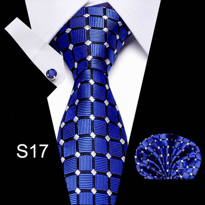Blue patterned tie with matching pocket square and cufflinks on a white background