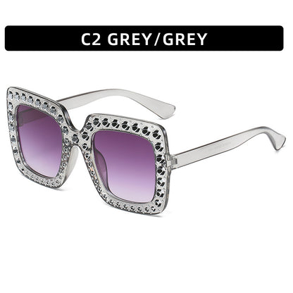 Sunglasses with decorative frame and purple lenses on a white background