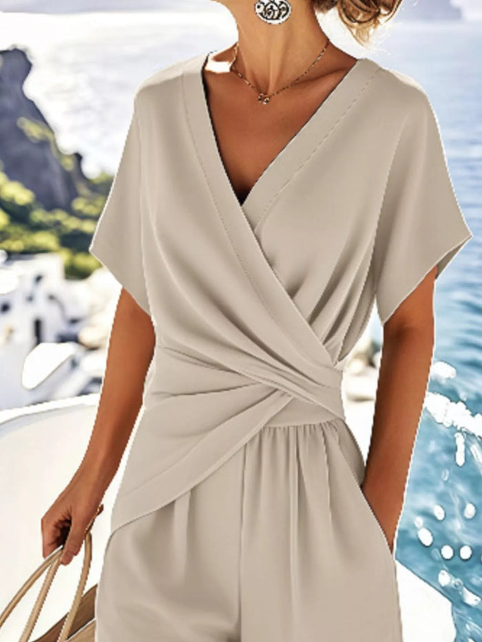 Beige dress worn by a person with a blurred coastal background