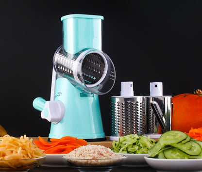 Turquoise manual vegetable grinder with sliced vegetables on a black background
