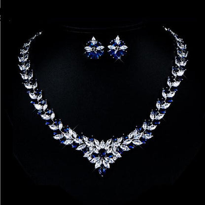 Jewelry set with necklace and earrings featuring blue and clear stones on a black background