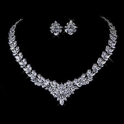 Silver necklace and earrings set on a black background