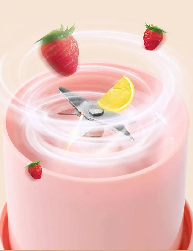 Pink portable juice blender with clear cup lid and visible stainless blending blades