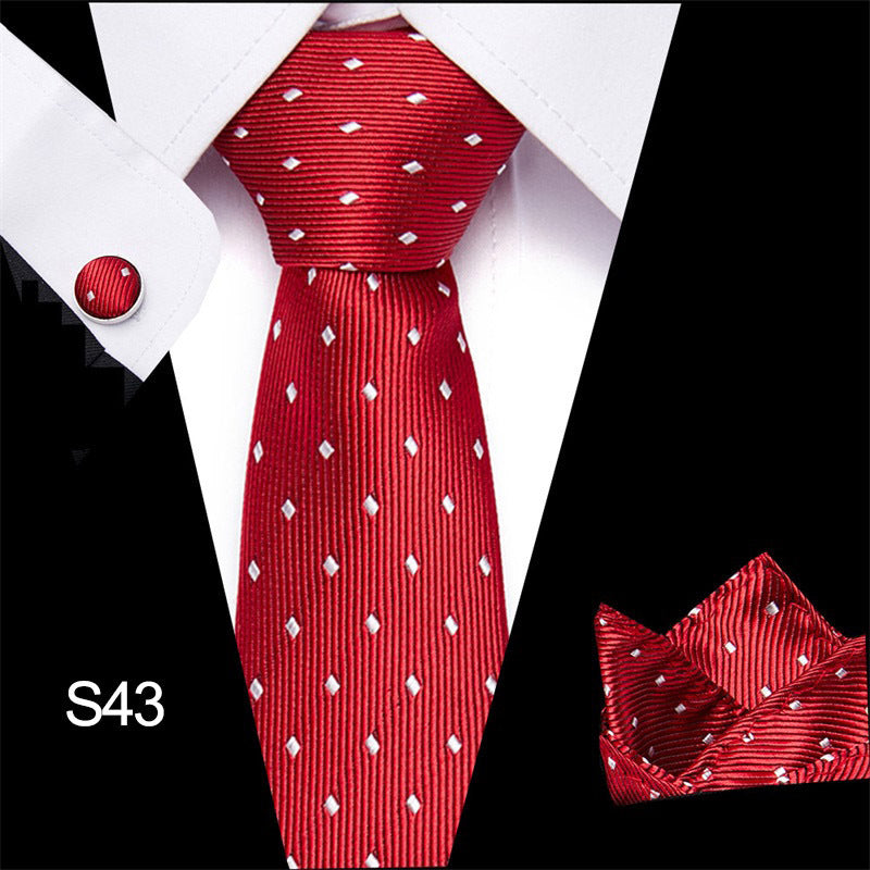 Red tie with white pattern, matching pocket square, and cufflinks on a black and white background.