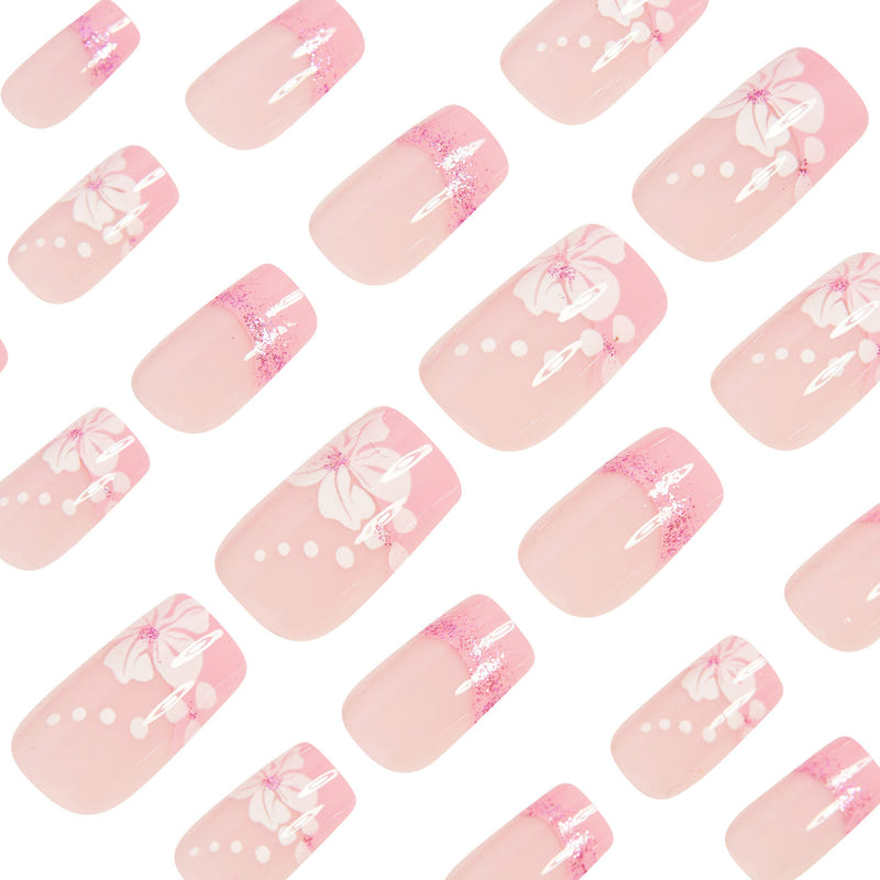 Set of pink press-on nails with French tips, glitter accents, and white bow/flower decals