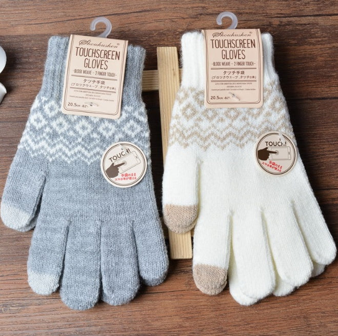 Pair of touchscreen gloves with labels on a wooden surface