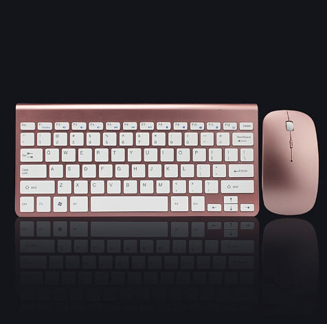 Rose gold wireless keyboard and mouse set on a black background