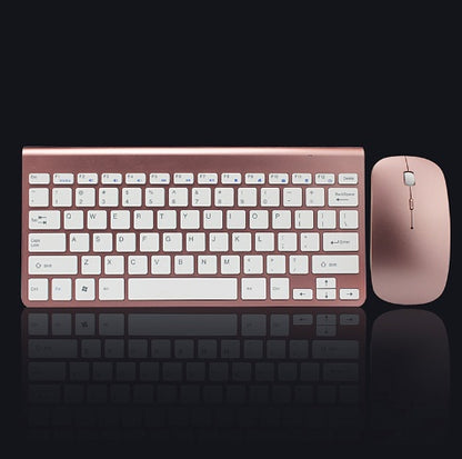 Rose gold wireless keyboard and mouse set on a black background