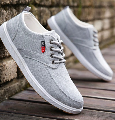 Gray sneakers with white soles on a wooden surface