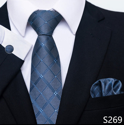 Blue patterned tie and pocket square set with a black suit and white shirt.