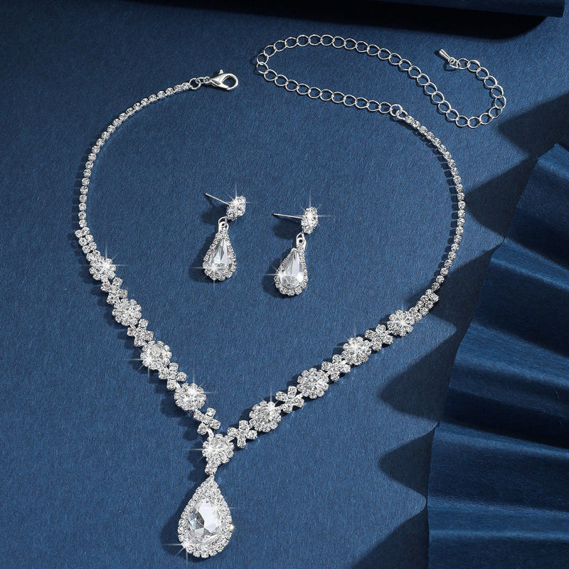 Silver bridal jewelry set with clear crystal drop necklace, earrings, and chain bracelet
