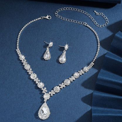 Silver bridal jewelry set with clear crystal drop necklace, earrings, and chain bracelet