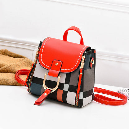 Red and black plaid crossbody bag with flap, buckle strap, and front zip pocket