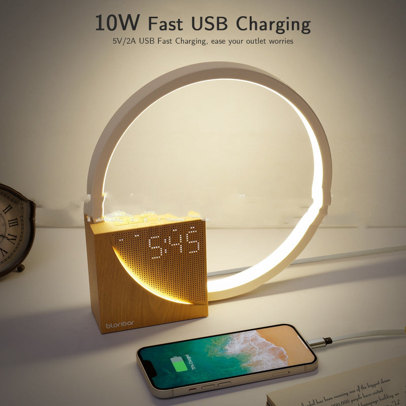 Smart clock with LED ring displaying time, connected to a smartphone for fast USB charging on a white surface.
