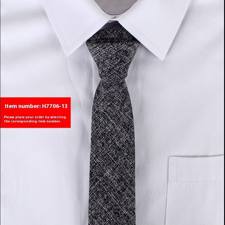 Black patterned tie on a white shirt with a red item number label.