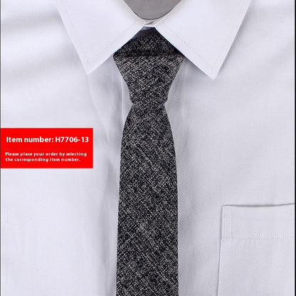 Black patterned tie on a white shirt with a red item number label.