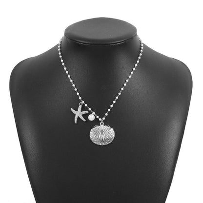 Necklace with starfish and shell pendant on a black mannequin bust