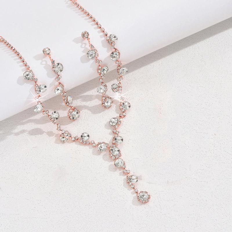 Rose gold necklace with crystal-like beads on a light background