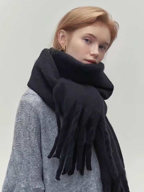 Person wearing a black scarf on a plain background