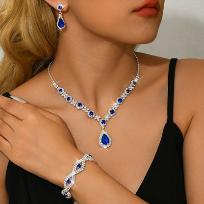 Woman wearing a blue and silver jewelry set including necklace, earrings, and bracelet.