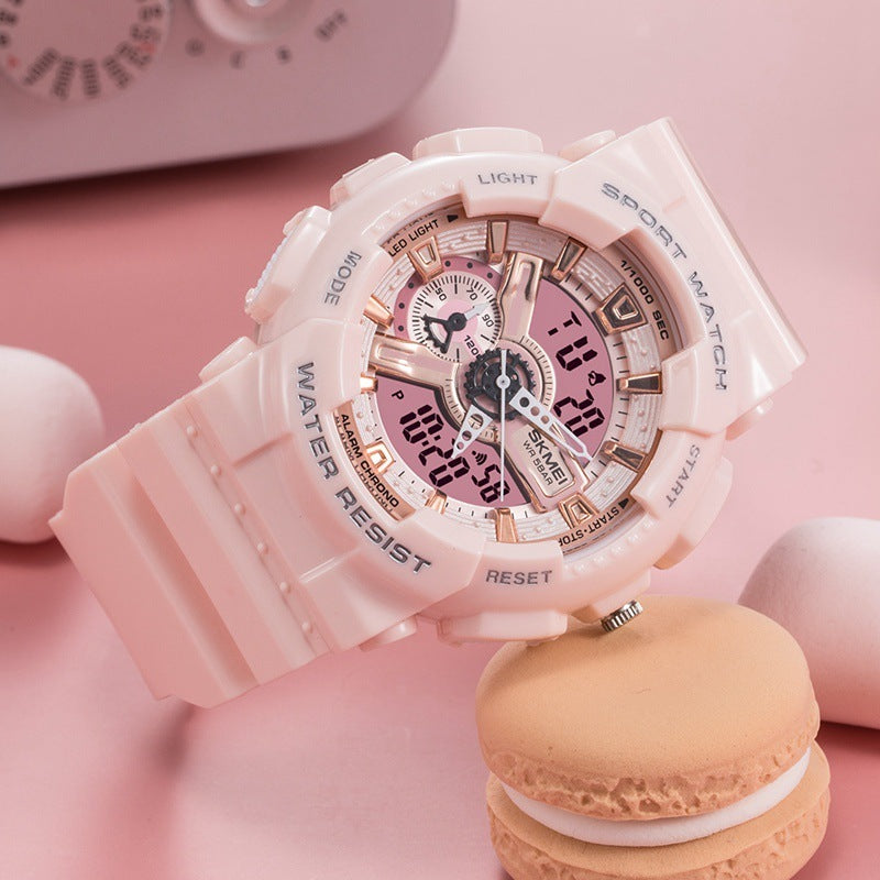 Pink watch with digital and analog display on a pink background with a macaron