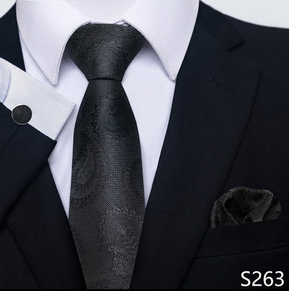 Black paisley tie with matching pocket square on a suit, brand 'S263' visible.
