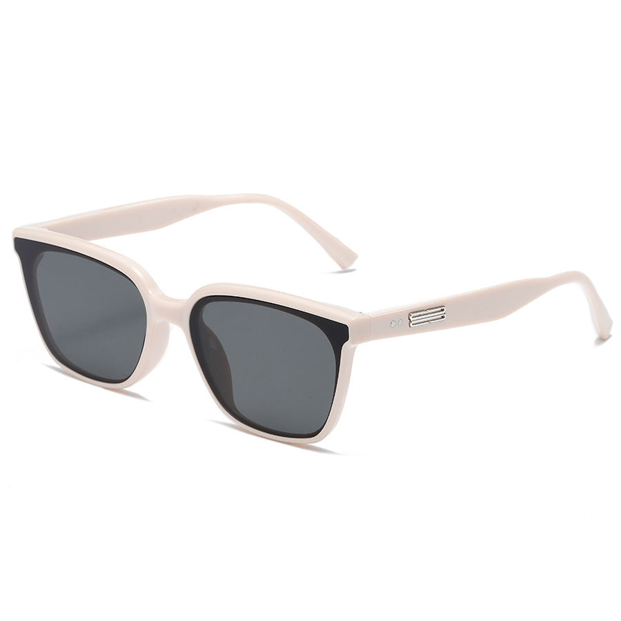 Beige sunglasses with dark lenses on a white background