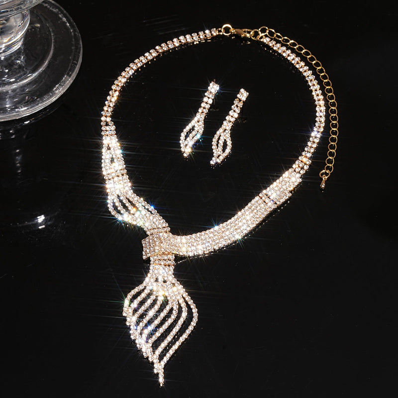 Necklace and earrings set with rhinestone details on a black background