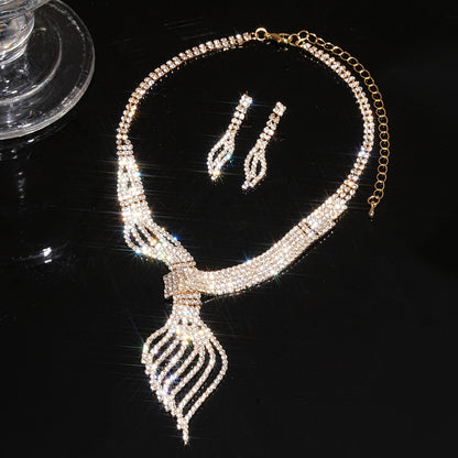 Necklace and earrings set with rhinestone details on a black background