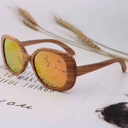 Wooden sunglasses with yellow lenses on a magazine with wheat stalks in the background