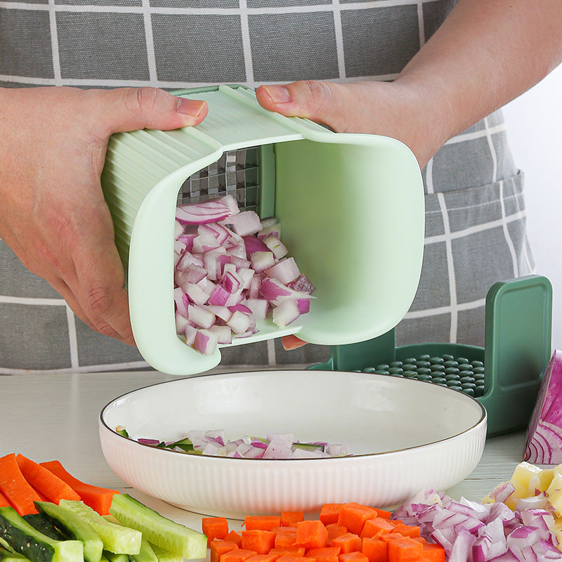 Person using a green vegetable chopper to chop onions, with the chopped onions being transferred into a white bowl.