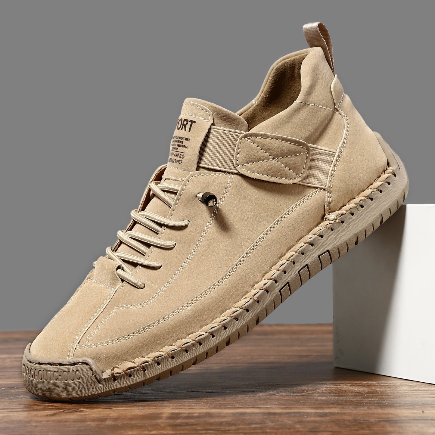 Men's mid-top leather lace-up shoe in light khaki with stitched trim and textured sole.